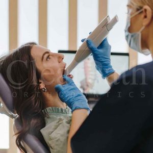 An orthodontist taking a patient's 3d dental impressions for designing a batch of invisible aligners